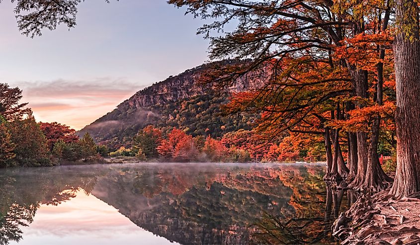 Colorful fall sunrise over Frio River and Old Baldy in Garner State Park