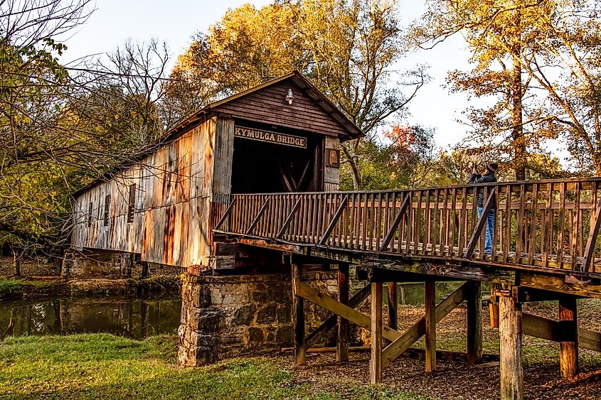 A tourist takes a photo of Kymulga Covered Bridge, one of only two 19th century covered bridges in Alabama still in its original location. Editorial credit: JNix / Shutterstock.com