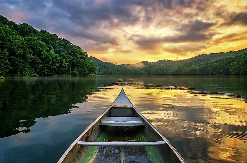 Dramatic sunset from an old canoe on a serene mountain lake in the Appalachian Mountains of Harlan, Kentucky.