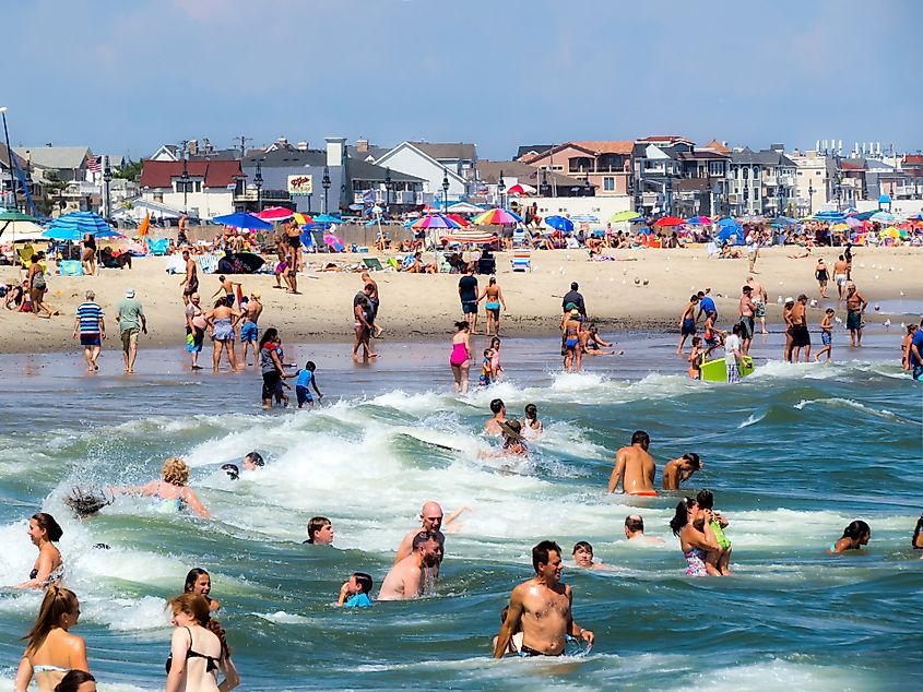 A crowd of sunbathers and swimmers enjoy a warm beach day in Spring Lake New Jersey.