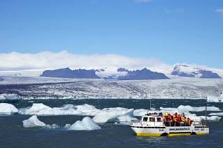 Amphibious Vehicle Between Icebergs on Glacial Lake at Jokulsarlon with Vatnajokull Icecap, Iceland