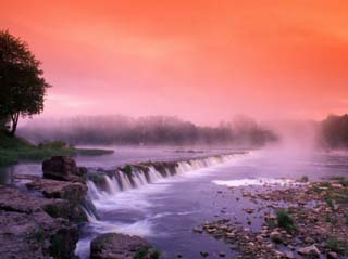 Sunrise in the morning mist over the waterfall on the Venta River near Kuldiga, Latvia