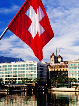 Swiss Flag on Mont Blanc Bridge with Quai General Guisan in Background, Geneva, Switzerland