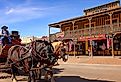 A stagecoach filled with tourists travels the historic streets of Tombstone, Arizona. Image credit CrackerClips Stock Media via Shutterstock