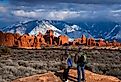 Couple in awe of La Sal Mountains at Arches National Park in Moab, Utah.