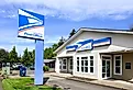 Main post office sign and building at Estacada, Oregon location. Image credit: Ian Dewar Photography via Shutterstock.