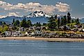 View of the Pacific Coast along the town of Bremerton, Washington, and mountains in the backdrop.