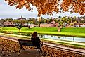 A woman sits on a bench in Grant Park during autumn in Galena, Illinois.