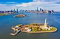 Aerial view of Statue of Liberty, Ellis Island, and Lower Manhattan skyline from New York Harbor near Liberty State Park in New Jersey. 