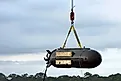 Black unmanned submarine being hoisted from the gulf of mexico