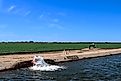 Groundwater is being pumped, from the San Joaquin Valley aquifer, into an irrigation canal, passing through California farmland.