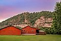 Rustic red cabin against bluff near Mountain Home, Arkansas.