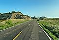 Driving through the badlands hills and mountains in Theodore Roosevelt National Park in North Dakota on a sunny day.