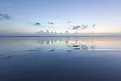 Ocean reflection of dusk sky on the beach. 