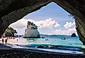 Cathedral Cove, beautiful beach with rocks and tourists in cave in Hahei, New Zealand. Image credit riekephotos via Shutterstock.com