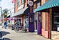 Sidewalk scene with people sitting at tables in front of East Frank's Superette Kitchen in Monroe, NC. Image credit Nolichuckyjake via Shutterstock.