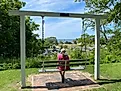 The author's mother sits peacefully on a swinging bench atop a lakeside bluff. Image credit: Andrew Douglas