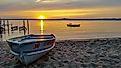 Sunset at Gull Lake, Minnesota, with row boat pulled onto sandy beach.