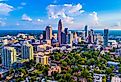 Charlotte North Carolina skyline on a bright sunny day with a few clouds in the sky.