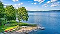 Keuka Lake surrounded by green trees during the summertime.