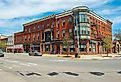 Historic sandstone and brick commercial buildings with Italianate style on Market Street at Main Street in downtown Potsdam, Upstate New York. Image credit Wangkun Jia via Shutterstock