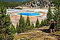 A hiker looking down on the Grand Prismatic Spring in Yellowstone National Park.