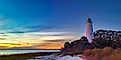 St. Marks Lighthouse at St. Marks Wildlife Refuge, silhouetted against a glowing sunset.