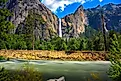 Bridalveil Fall cascading into Yosemite Valley with the Merced River in the foreground in Yosemite National Park, California. 