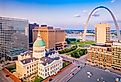 St. Louis, Missouri, US downtown cityscape with the arch and courthouse at dusk.