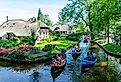 Folks cruising on the canals in Giethoorn, Netherlands. Editorial credit: rob3rt82 / Shutterstock.com