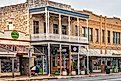 The shoppes housed in old historic buildings along Main Street through Fredericksburg, Texas, part of US 290, on a late spring morning.