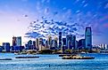 The skyline of Jersey City, New Jersey from New York harbor with the Statue of Liberty in the foreground.