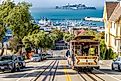 The Cable car tram and Alcatraz prison island on a background in San Francisco, California, via Sergii Figurnyi / Shutterstock.com