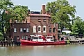 Fire Boat on the River A boat equipped for fire fighting is docked at a brick fire station on the Cuyahoga River in Cleveland, Ohio. 