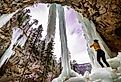 Girl standing under frozen waterfall in Spearfish, South Dakota.