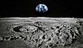 View of Moon limb with Earth rising on the horizon. Footprints as an evidence of people being there or great forgery. Collage. Elements of this image furnished by NASA.