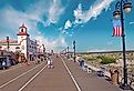 People walking along the famous boardwalk in late afternoon in Ocean City, New Jersey. Image credit: Vlad G via Shutterstock.