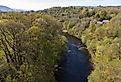 Aerial vew of the Dee River in Llangollen, Denbighshire, Wales. Green forests line the river. Image credit Tomasz Wozniak via Shutterstock.