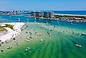 Aerial view of boats and people on the water and sandy beaches at Orange Beach, Alabama.