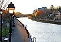 A jogger running along the Erie Canal Path in Fairport, at sunrise on a clear, blue sky morning. Fall colors are displayed on surrounding trees. Image credit Hike Kayak Fish via Shutterstock.com 