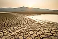 Cracked, dry lakebed caused by extreme heat and drought, illustrating the impact of climate change during summer.