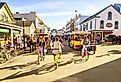 Vacationers ride bicycles along Market Street on Mackinac Island, Michigan. Image credit Alexey Stiop via Shutterstock