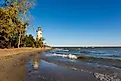 The historic Pelee Island Lighthouse, built in 1833, reflecting on its Lake Erie shoreline.