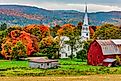 A rustic barn and church during autumn in the town of Woodstock, Vermont. Editorial credit: MindStorm / Shutterstock.com