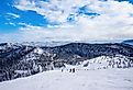 Unidentifiable skiers going down from the summit at Big Mountain in Whitefish, Montana, west of Glacier National Park, USA.