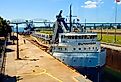Great Lakes freighters passes through the Soo Locks at Sault Ste Marie Michigan connecting Lake Superior with Lake Huron. Image credit Dennis MacDonald via Shutterstock