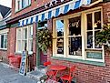 Exterior of a cafe with a striped awning and red tables and chairs in downtown Stroudsburg, Pennsylvania. Editorial credit: Here Now / Shutterstock.com