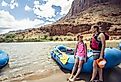 Smiling child and adult women ready to board a large inflatable raft as they travel down the scenic Colorado River near Moab, Utah and Arches National Park.