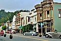 Classic cars line Main Street in front of colorful historic buildings in downtown Ferndale, a preserved Victorian-era town on the California coast.