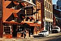 A young couple walks under the awning and sign of the Ye Olde Union Oyster House, in Boston, on a cold winter day. Credit: James Kirkikis/ Shutterstock